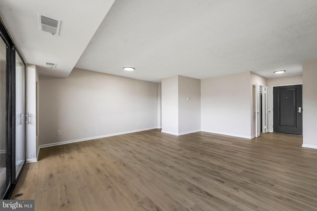 interior space featuring baseboards, visible vents, and wood finished floors