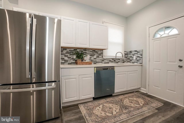 kitchen featuring dark wood finished floors, dishwasher, light countertops, a sink, and freestanding refrigerator