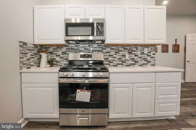 kitchen with stainless steel appliances, dark wood-style floors, and white cabinetry