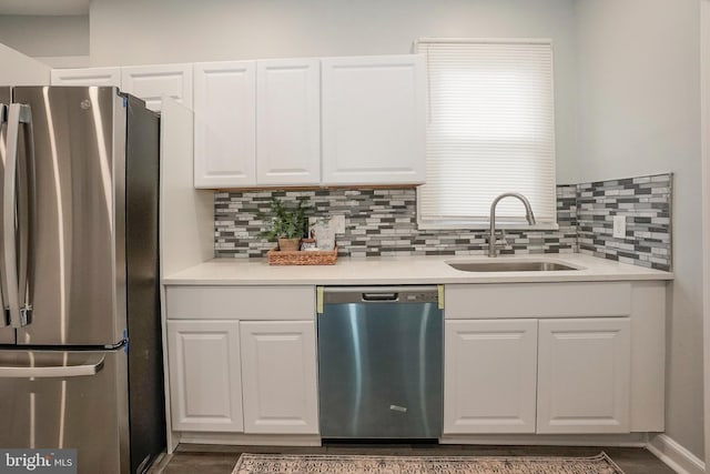 kitchen featuring backsplash, white cabinetry, appliances with stainless steel finishes, and a sink