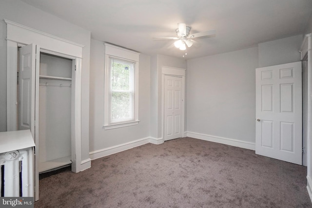 unfurnished bedroom featuring a ceiling fan, baseboards, two closets, radiator heating unit, and carpet flooring