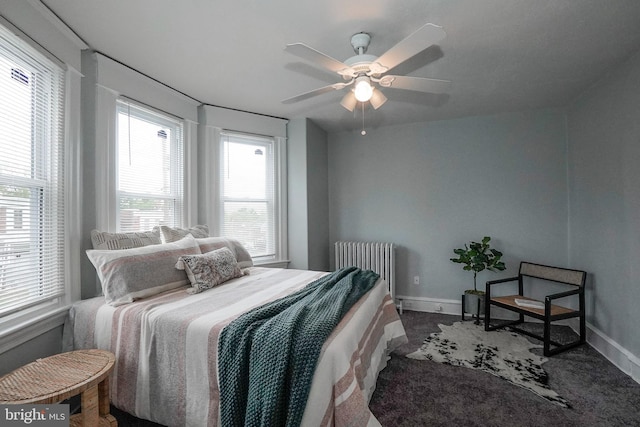 bedroom with radiator heating unit, baseboards, and a ceiling fan