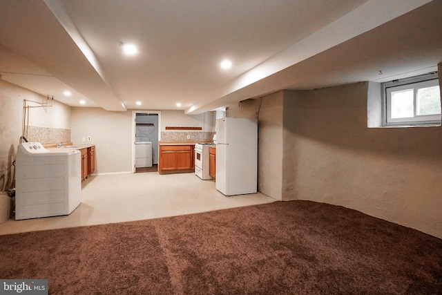 below grade area with washer and dryer, freestanding refrigerator, recessed lighting, and light colored carpet