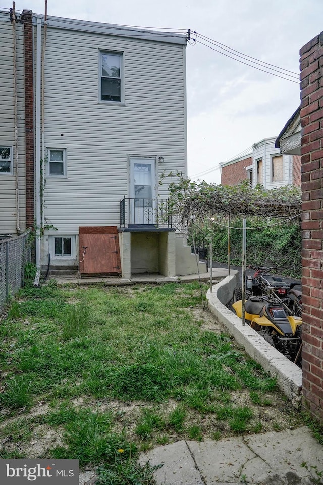 rear view of property featuring fence