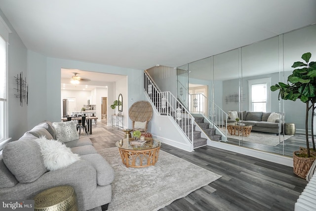 living room with stairs, baseboards, and wood finished floors
