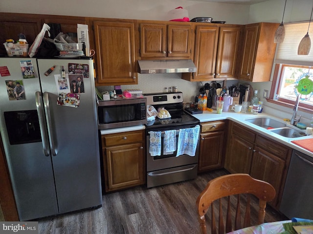 kitchen featuring dark wood-style flooring, light countertops, ventilation hood, a sink, and stainless steel appliances