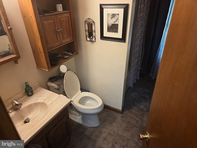 bathroom featuring vanity, tile patterned flooring, baseboards, and toilet