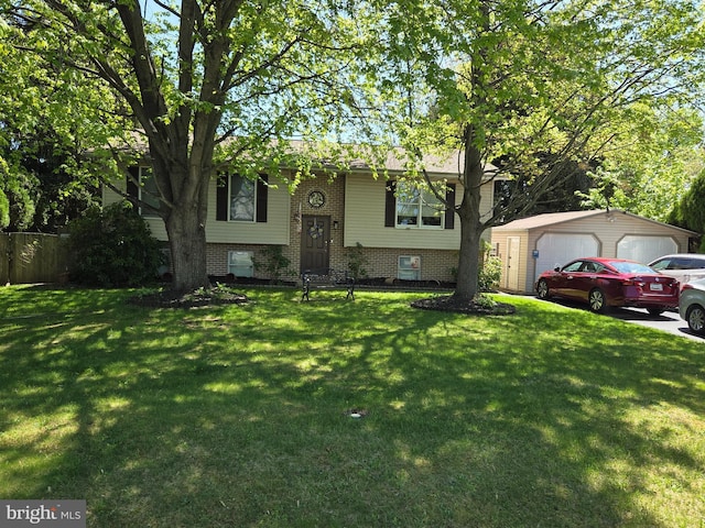 bi-level home featuring a detached garage, an outdoor structure, and a front yard