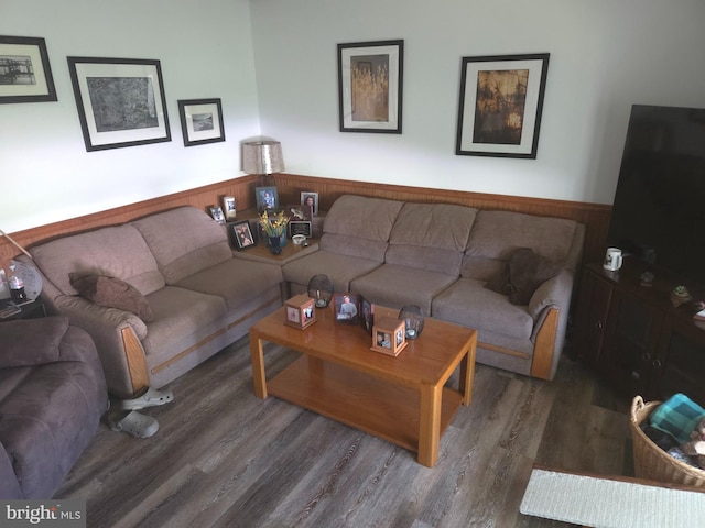 living area featuring wood finished floors and a wainscoted wall