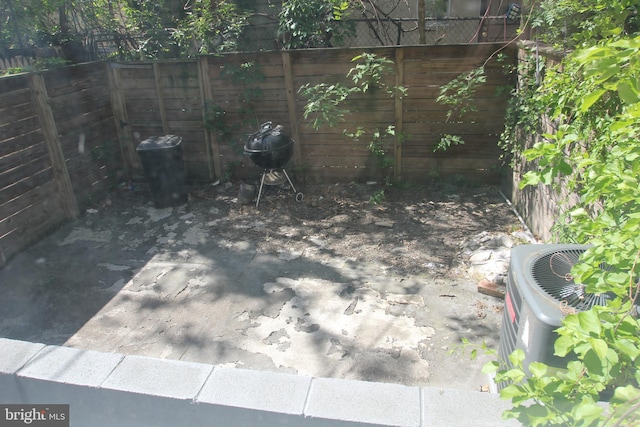view of yard featuring central AC and fence