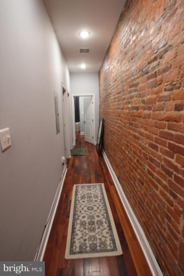 hallway featuring baseboards, wood finished floors, and visible vents