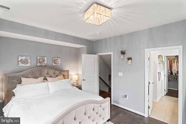 6101 Enquirer St, Hyattsville, MD 20782 - bedroom featuring baseboards, a walk in closet, wood finished floors, and a chandelier