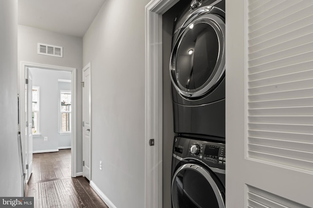 6101 Enquirer St, Hyattsville, MD 20782 - laundry room with stacked washer / drying machine, dark wood-style flooring, and baseboards