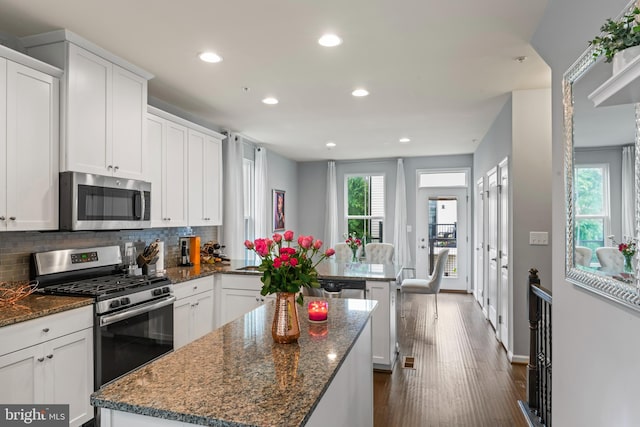 6101 Enquirer St, Hyattsville, MD 20782 - kitchen featuring appliances with stainless steel finishes, a peninsula, recessed lighting, tasteful backsplash, and a center island
