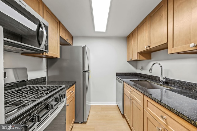 565 W Diamond Ave Unit 27, Gaithersburg, MD 20877 - kitchen with appliances with stainless steel finishes, a sink, light wood-style flooring, dark stone countertops, and baseboards