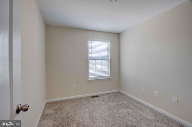 spare room featuring carpet flooring and baseboards