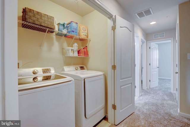 washroom featuring separate washer and dryer, light carpet, and baseboards
