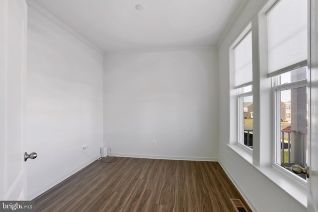 unfurnished room featuring ornamental molding, dark wood finished floors, and a healthy amount of sunlight