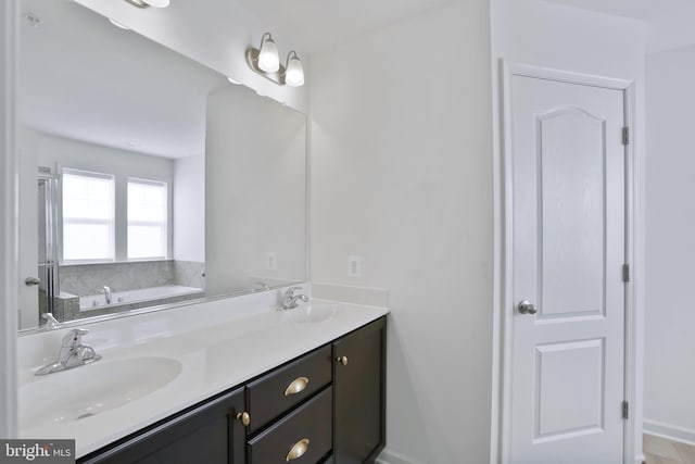 bathroom with double vanity, a sink, and a garden tub