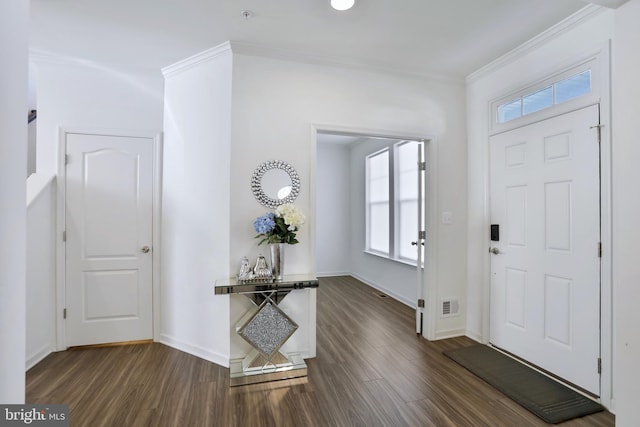 foyer entrance featuring dark wood-style flooring, baseboards, visible vents, and ornamental molding