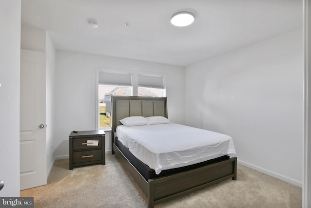 bedroom featuring baseboards and light colored carpet