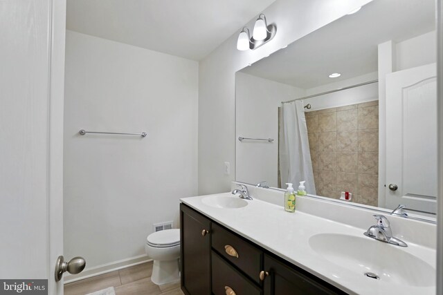 bathroom featuring a sink, toilet, double vanity, and a shower with shower curtain