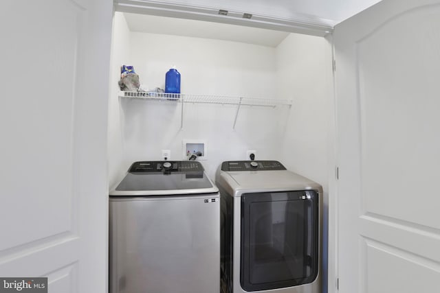 clothes washing area with separate washer and dryer and laundry area
