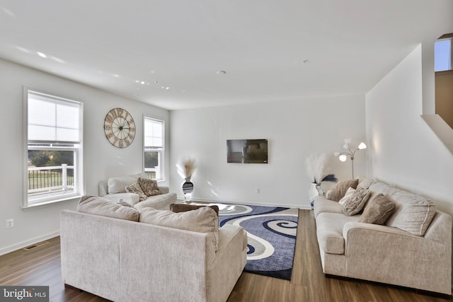 living room featuring baseboards, dark wood-style flooring, and visible vents