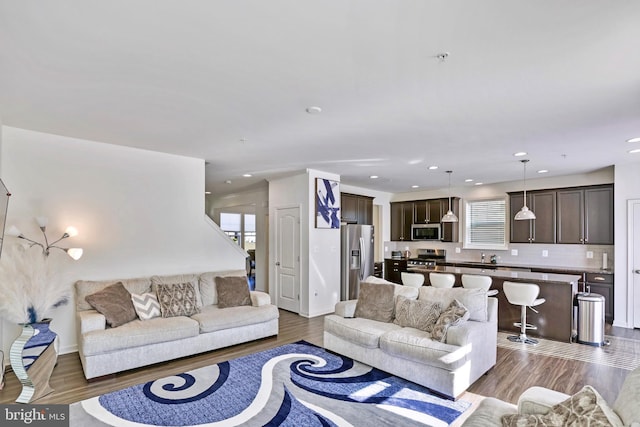 living area featuring baseboards, recessed lighting, and wood finished floors