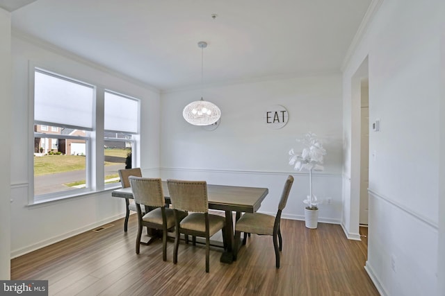 dining space with crown molding, dark wood finished floors, and visible vents