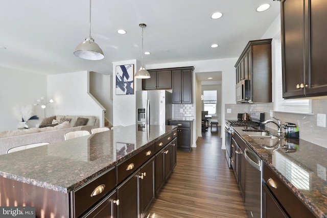 kitchen featuring dark wood-style flooring, dark brown cabinets, a sink, a center island, and stainless steel appliances