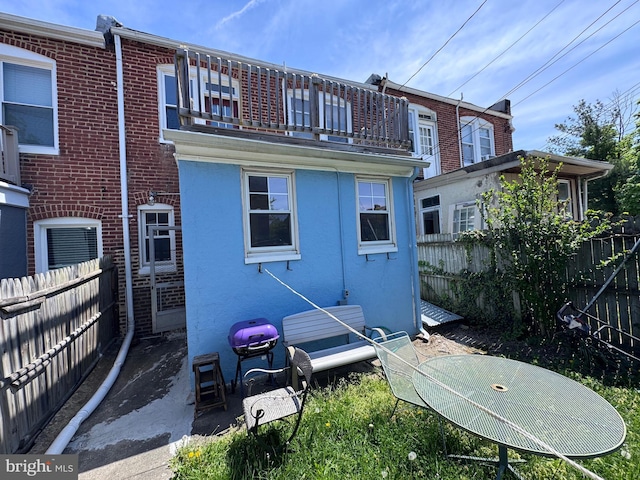 4702 Kernwood Ave, Baltimore, MD 21212 - rear view of property featuring a balcony, a fenced backyard, and stucco siding