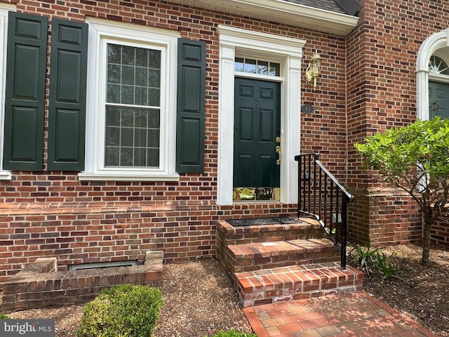 property entrance featuring brick siding