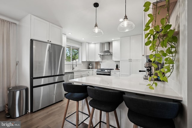 48 Evergreen Ln, Burlington, NJ 08016 - kitchen featuring wall chimney range hood, stainless steel appliances, a peninsula, wood finished floors, and tasteful backsplash