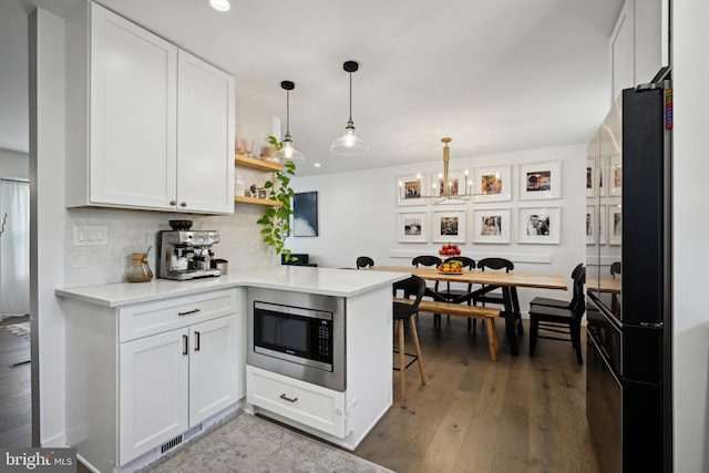 48 Evergreen Ln, Burlington, NJ 08016 - kitchen featuring tasteful backsplash, open shelves, white cabinets, stainless steel microwave, and an inviting chandelier