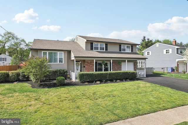48 Evergreen Ln, Burlington, NJ 08016 - split level home featuring aphalt driveway, fence, a front yard, brick siding, and a shingled roof