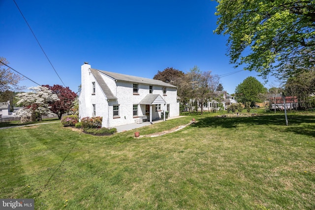 rear view of property with a yard and a chimney