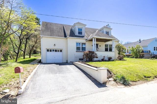 view of front of property with an attached garage, driveway, stucco siding, and a front yard