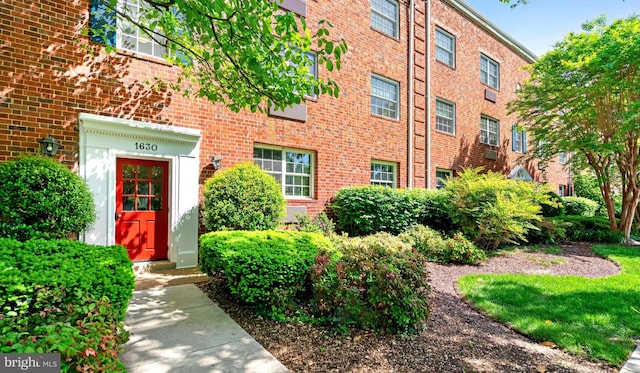 entrance to property featuring brick siding