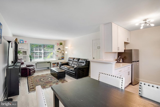 living area featuring light wood-style floors and baseboards