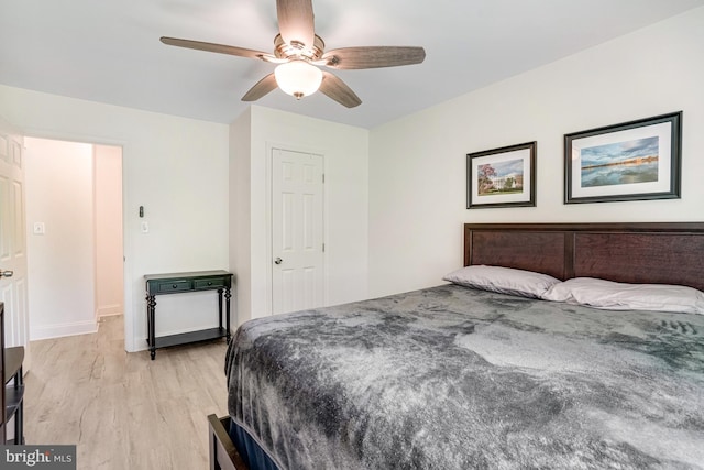 bedroom with baseboards, ceiling fan, and light wood-style flooring
