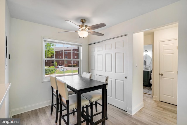 dining area with light wood-style floors, baseboards, and ceiling fan