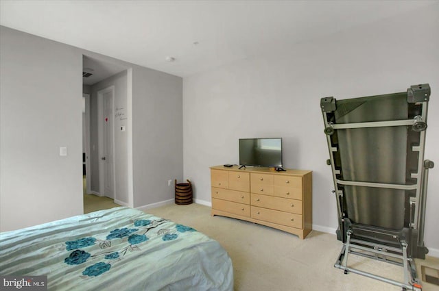 bedroom with baseboards and light carpet