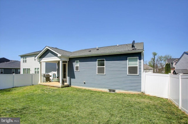 back of house featuring a fenced backyard, a shingled roof, a yard, and a deck
