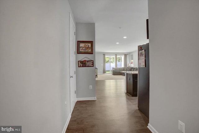 hall with recessed lighting, baseboards, and dark wood-style floors
