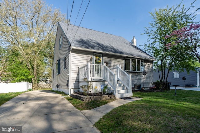 view of front of property with fence, a front yard, a chimney, a shingled roof, and central air condition unit