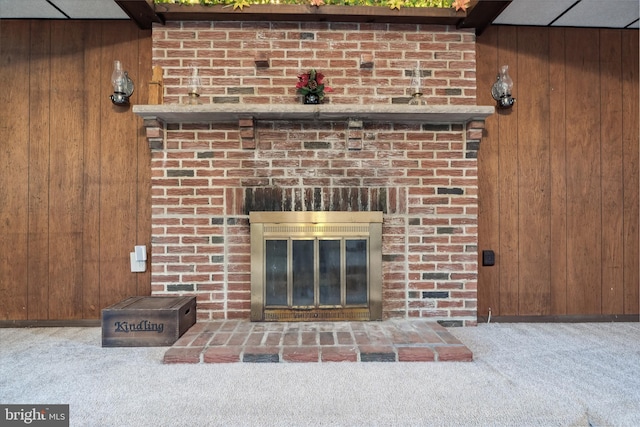 interior details featuring wooden walls, carpet floors, and a fireplace