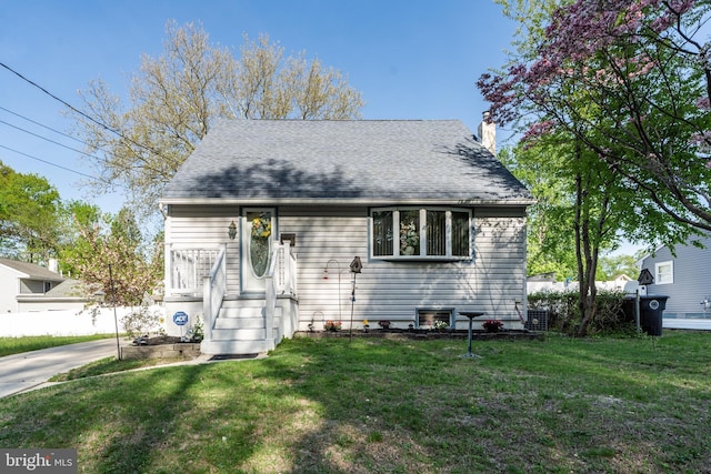 cape cod house featuring a chimney, central AC unit, and a front lawn