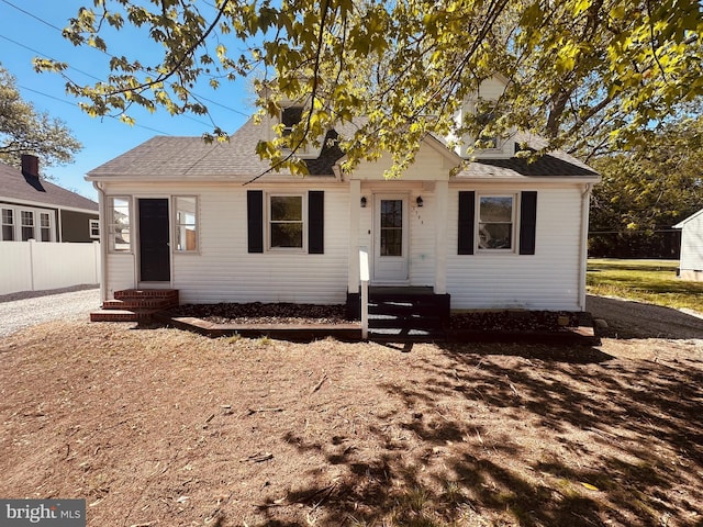 bungalow-style house with entry steps, fence, and a shingled roof