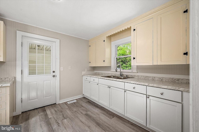 2708 Old Ocean City Rd, Salisbury, MD 21804 - kitchen featuring a sink, light wood-type flooring, light countertops, baseboards, and crown molding